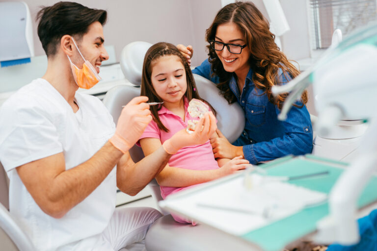 child at dentist with parent next to the chair